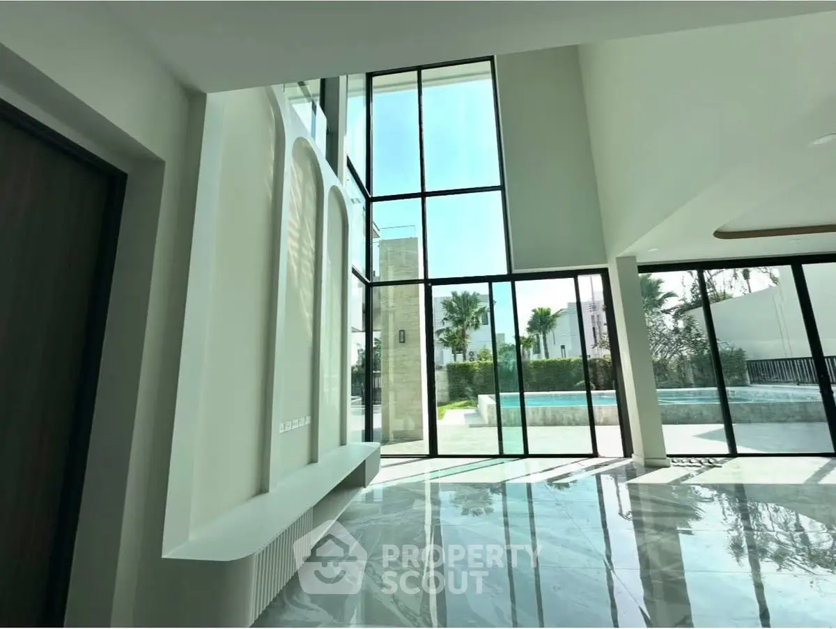 Luxurious modern living room with floor-to-ceiling windows and pool view