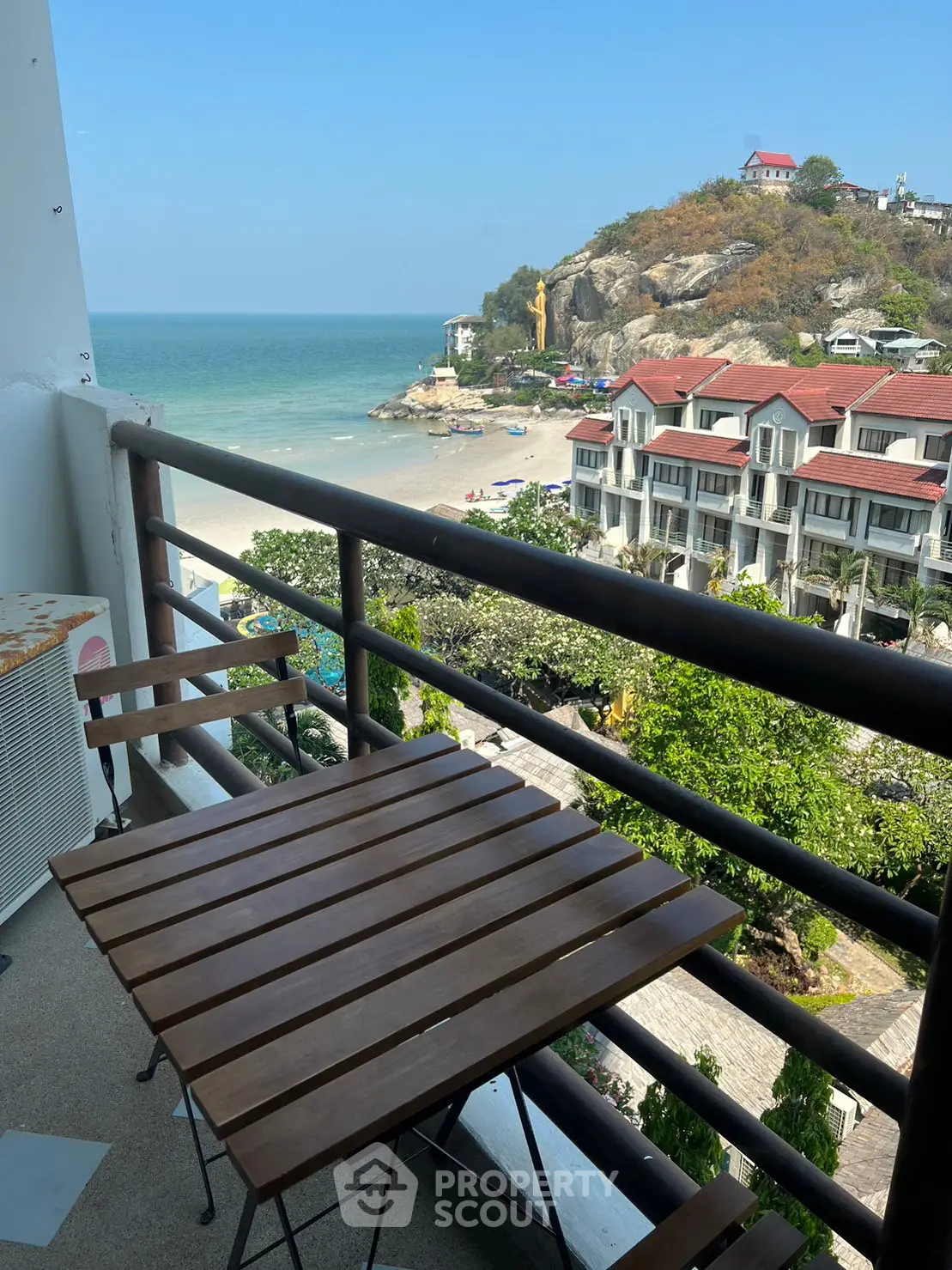 Stunning beachfront balcony view with ocean and hillside scenery, perfect for relaxation and enjoyment.