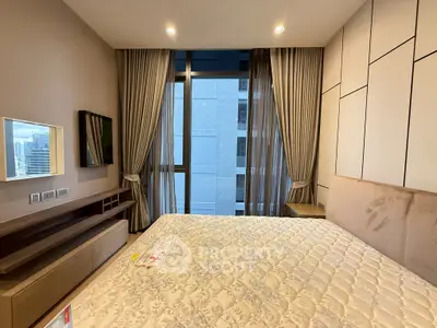 Luxurious bedroom with modern decor and city view, featuring elegant curtains and stylish furniture.