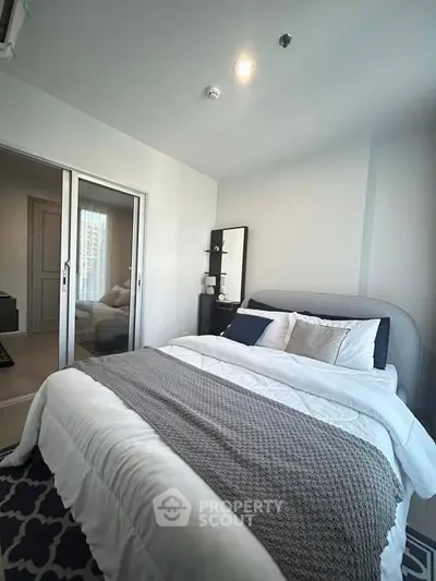 Cozy bedroom with modern decor and ample natural light, featuring a comfortable bed and stylish furnishings.