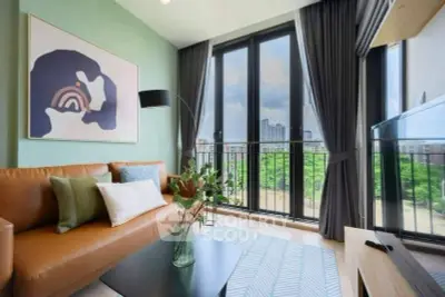 Modern living room with large windows and stylish decor in urban apartment.