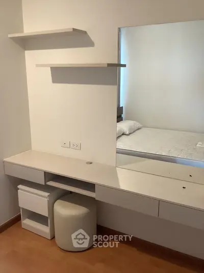 Modern bedroom with built-in desk and mirror, featuring minimalist design and ample storage space.