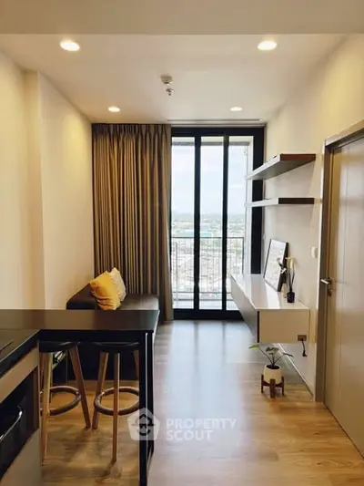Modern living room with balcony view, stylish decor, and natural light.