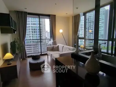 Modern living room with city view, featuring stylish furniture and large windows for natural light.