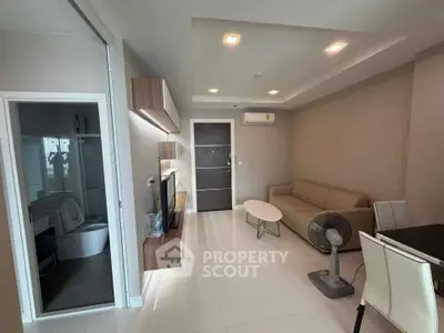 Modern living room with sleek furniture and neutral tones, featuring a cozy sofa and stylish lighting.