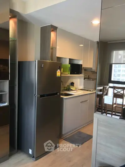 Modern kitchen with sleek appliances and stylish cabinetry in a contemporary apartment.