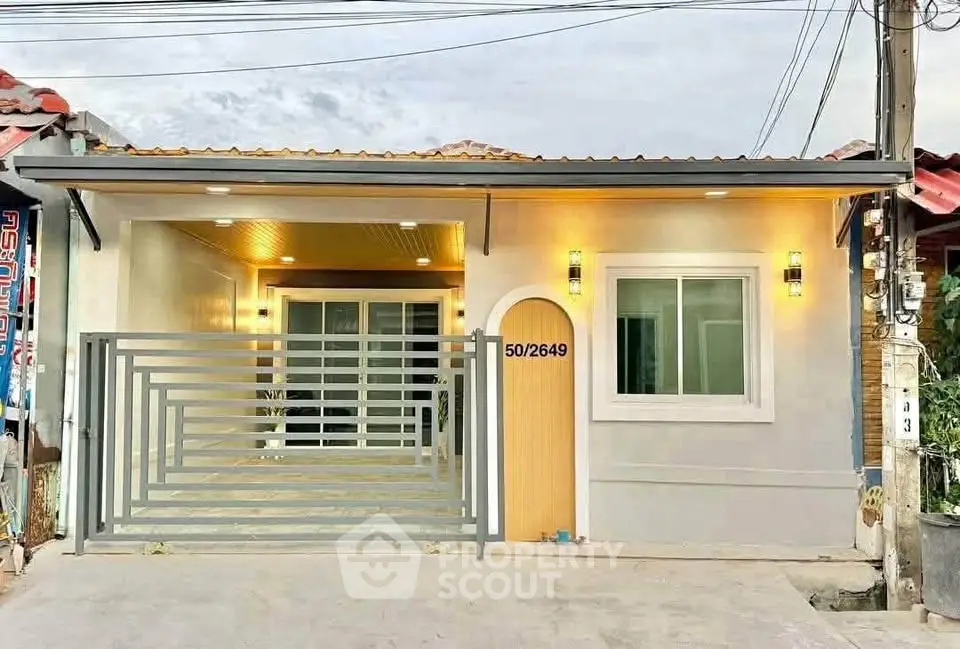 Charming single-story home with modern facade and gated entrance, perfect for cozy living.