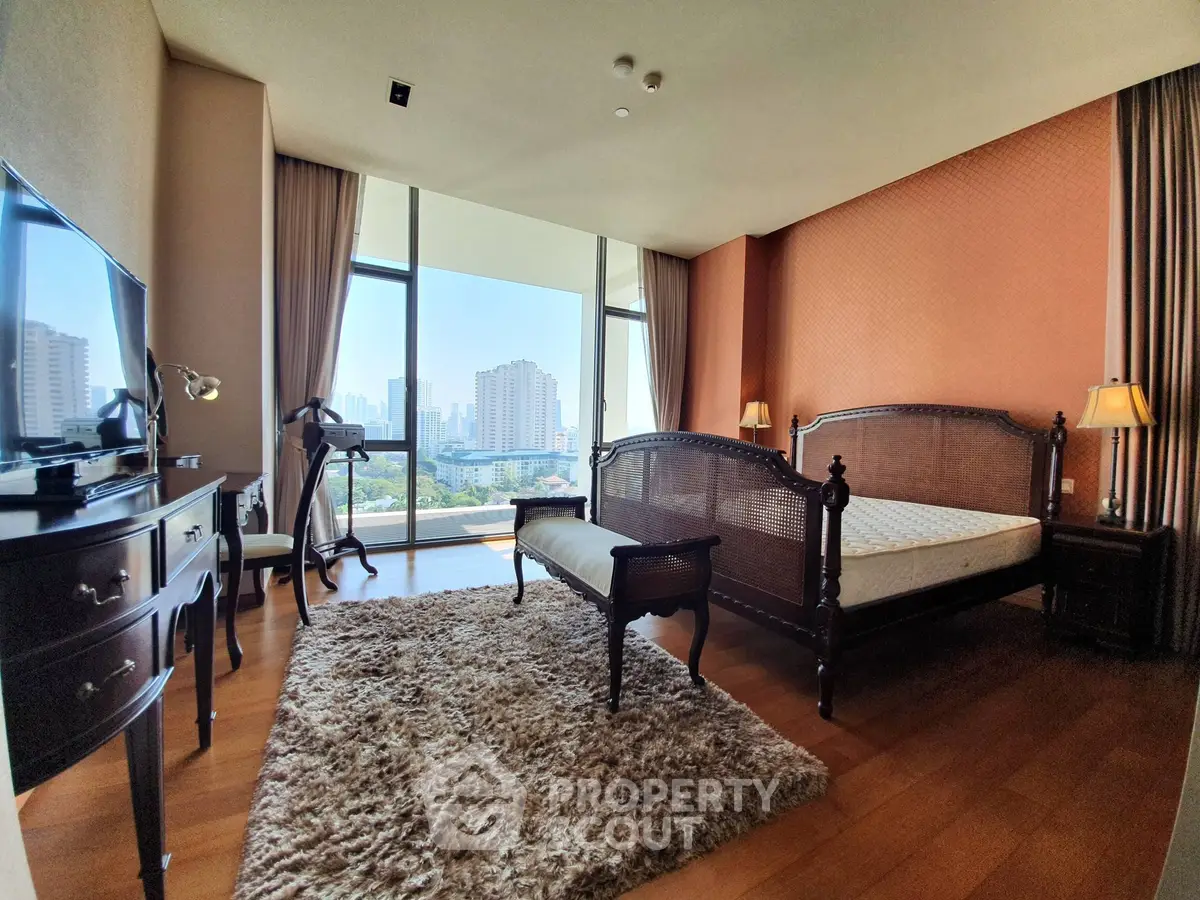 Luxurious bedroom with elegant furniture and stunning city view, featuring large windows and warm decor.