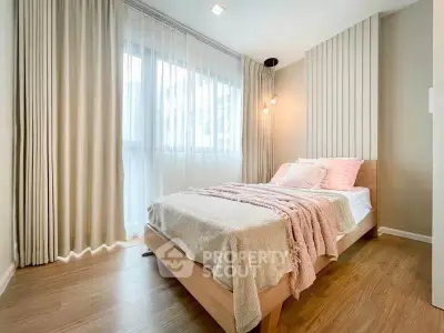 Bright and cozy bedroom with modern decor and large window for natural light.