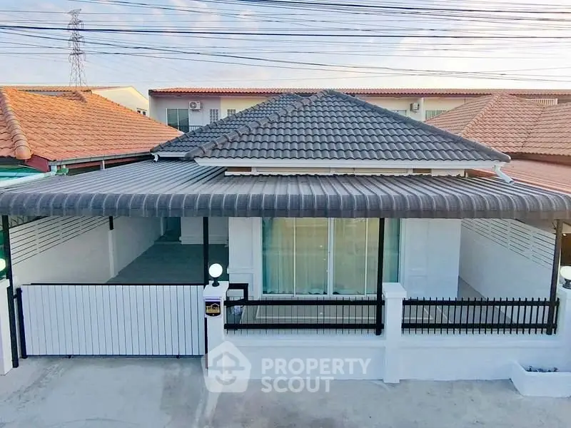 Charming single-story home with tiled roof and gated entrance in a serene neighborhood.