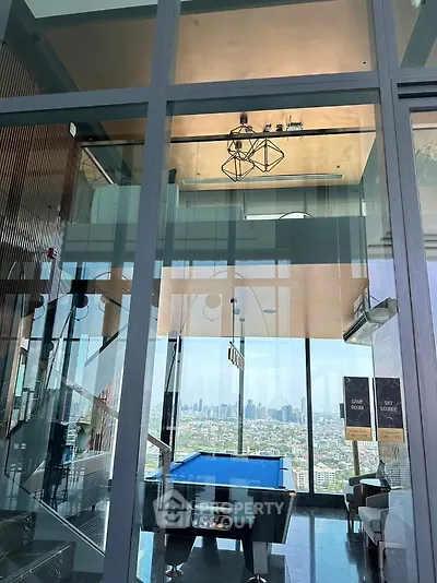 Luxurious high-rise apartment with stunning city view and modern interior design featuring a pool table.