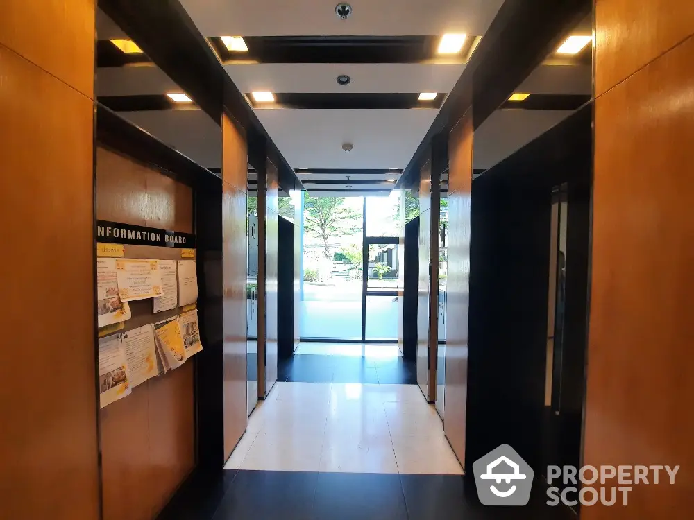 Elegant building entrance with modern elevator lobby and information board.