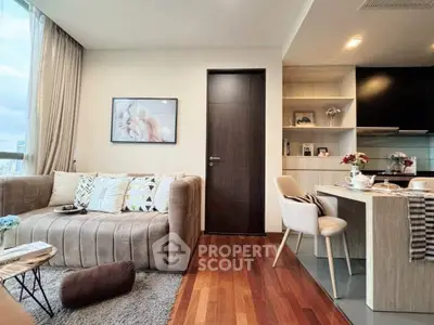 Modern living room with cozy seating and stylish kitchen in open layout apartment.