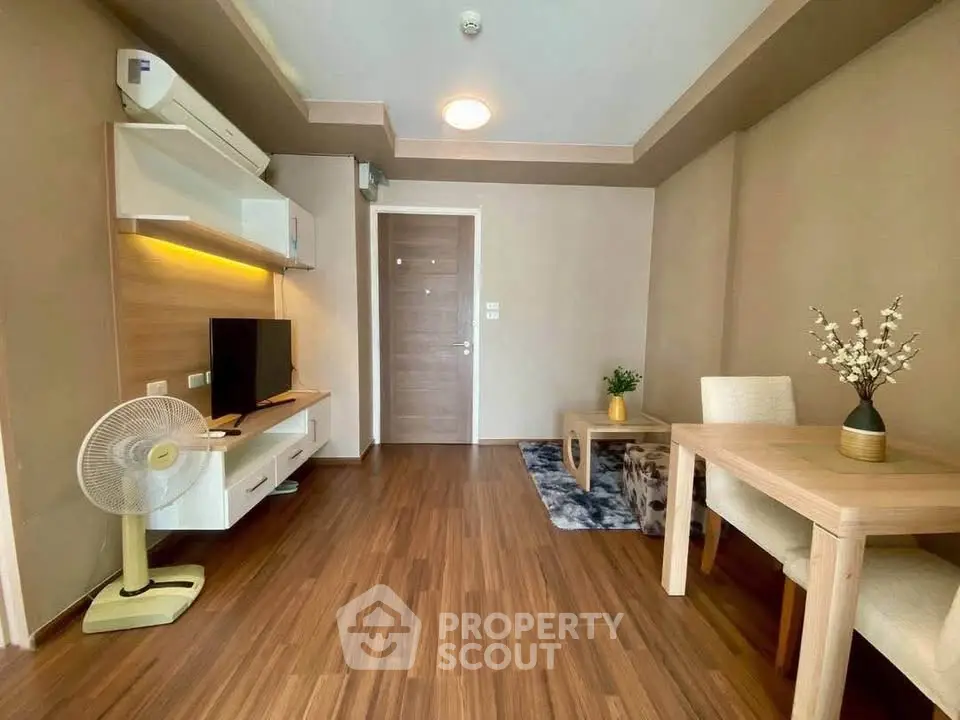 Modern living room with wooden flooring, stylish furniture, and ambient lighting.