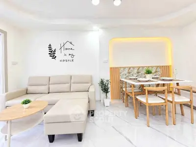Modern living room with cozy beige sofa and elegant dining area, perfect for family gatherings.