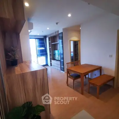 Modern living room with wooden furniture and open balcony view