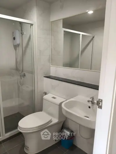 Modern bathroom with shower enclosure and sleek fixtures in a contemporary apartment.