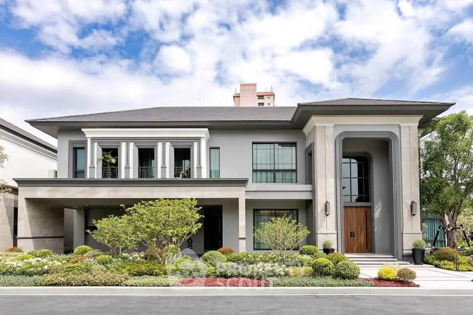 Luxurious modern two-story house with elegant facade and lush landscaping.