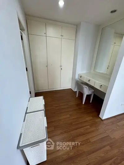 Spacious bedroom with elegant built-in wardrobe and stylish vanity area.