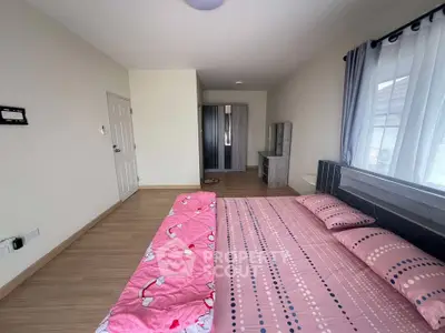 Spacious bedroom with modern decor and ample natural light, featuring a stylish bed and wardrobe.