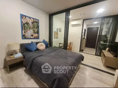Modern bedroom with stylish decor and sliding glass doors in a contemporary apartment.