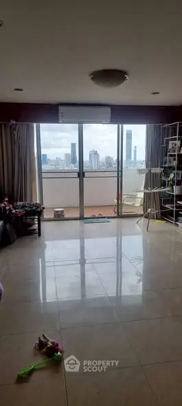 Spacious living room with city view and large balcony access.