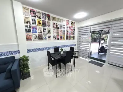Modern living room with stylish decor and wall art, featuring sleek furniture and large windows for natural light.