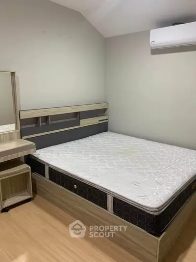 Modern bedroom with wooden furniture and air conditioning, perfect for comfort and relaxation.