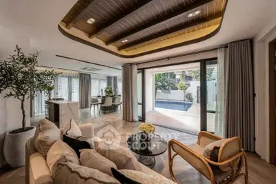Luxurious living room with elegant decor and pool view, featuring modern furniture and open layout.