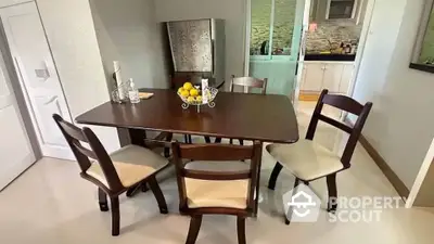 Charming dining area with elegant wooden table and chairs, adjacent to a modern kitchen.