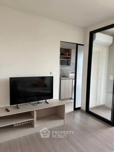 Modern living room with sleek TV stand and open kitchen view