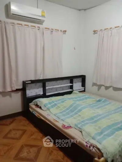 Cozy bedroom with air conditioning and patterned flooring, ideal for restful nights.