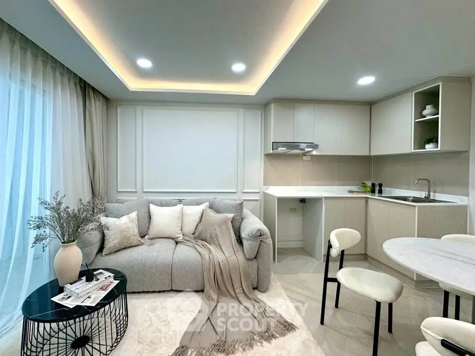 Modern living room with cozy sofa, elegant decor, and sleek kitchen in open layout design.