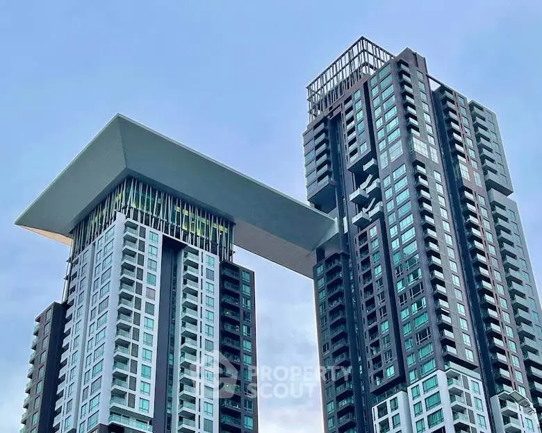 Stunning modern high-rise building with unique architectural design and sky bridge.