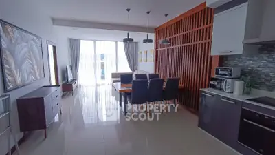 Modern open-layout living room and kitchen with stylish decor and ample natural light.