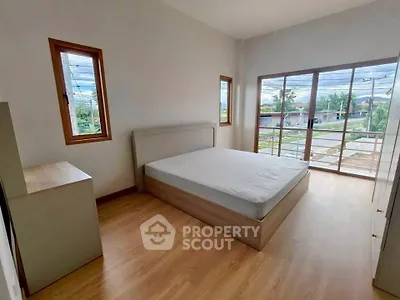Spacious bedroom with large windows and scenic view, perfect for relaxation.