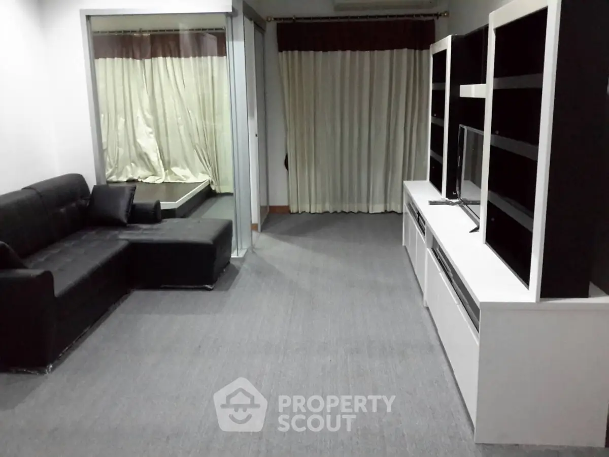 Spacious living room with modern black sofa and sleek entertainment unit