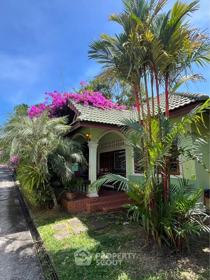 Charming tropical house with lush garden and vibrant bougainvillea, perfect for serene living.