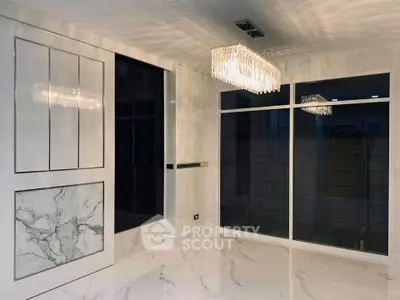 Luxurious modern interior with marble flooring and elegant chandelier lighting.