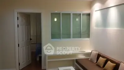 Cozy living room with modern lighting and a glimpse into the bedroom, perfect for urban living.