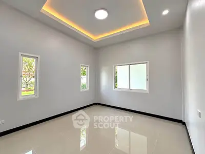 Spacious modern room with recessed lighting and large windows