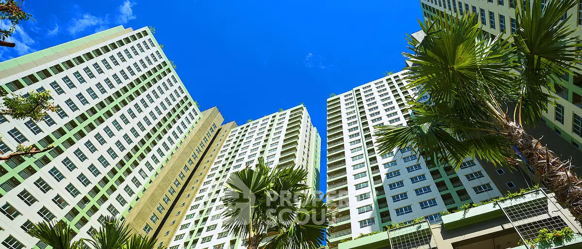 Stunning high-rise apartment buildings with lush palm trees and clear blue sky.
