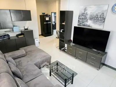 Modern living room with sleek furniture and large TV, perfect for relaxation.