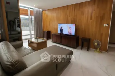 Modern living room with sleek leather sofa and wooden accent wall