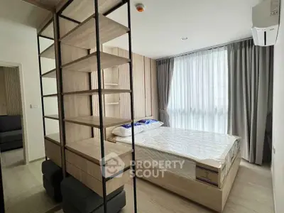 Modern bedroom with stylish shelving and large window in contemporary apartment.