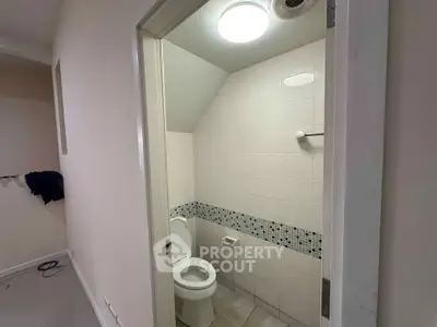 Compact bathroom with modern tile design and efficient lighting