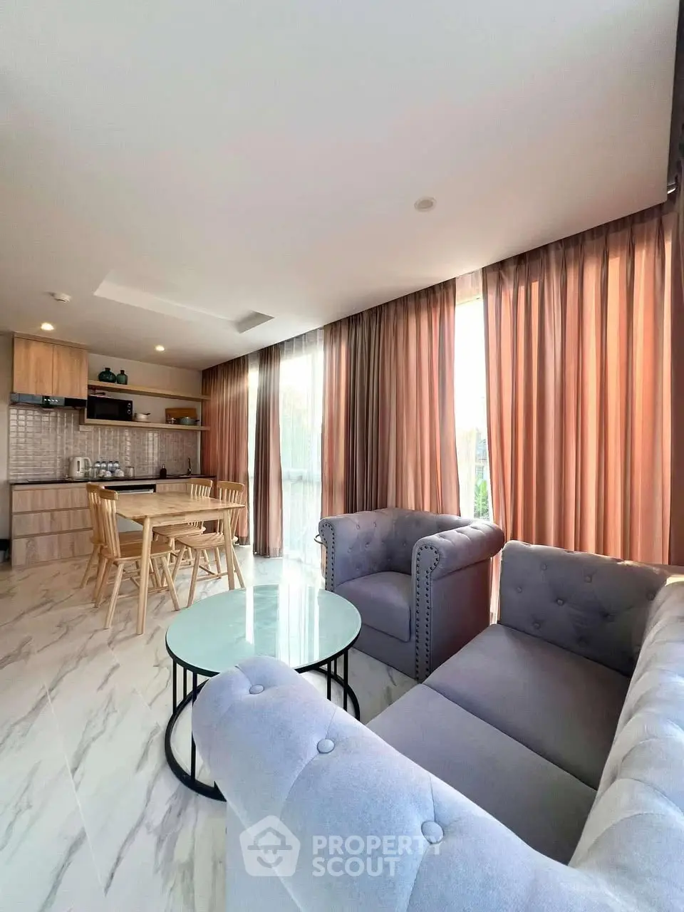 Spacious open-layout living room with modern kitchen and elegant furnishings