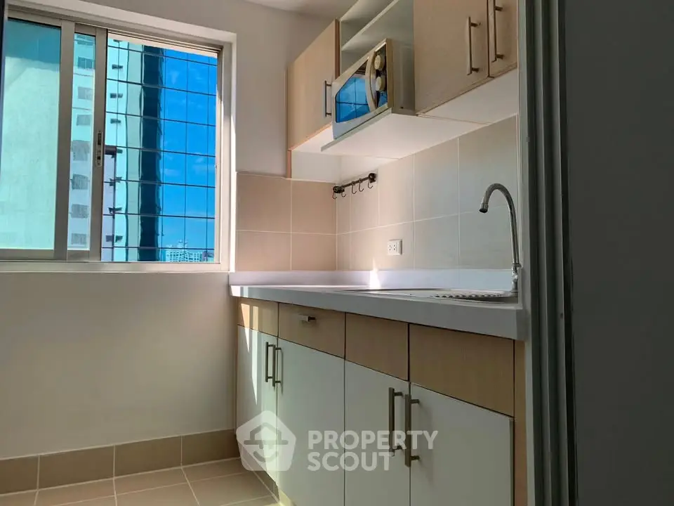 Modern kitchen with natural light and sleek cabinetry in urban apartment