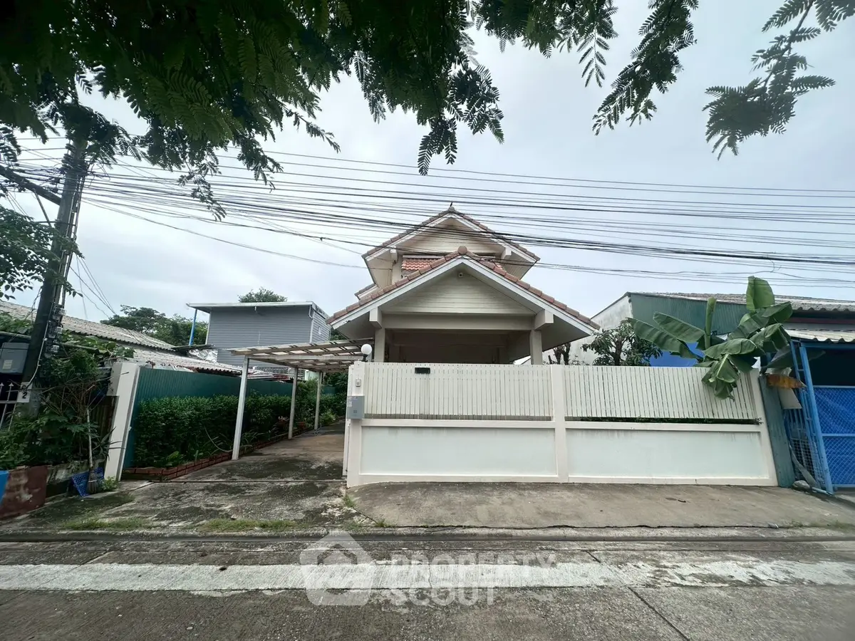 Charming suburban house with gated entrance and lush greenery, perfect for family living.