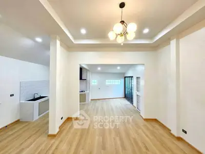Spacious open-plan living area with modern kitchen and elegant lighting
